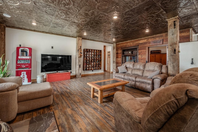 living area with hardwood / wood-style flooring, an ornate ceiling, decorative columns, and baseboards