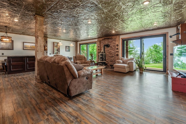 living area featuring an ornate ceiling, a wood stove, and dark wood finished floors