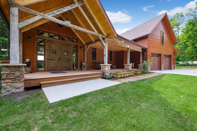 back of property with a garage, a shingled roof, concrete driveway, covered porch, and a yard