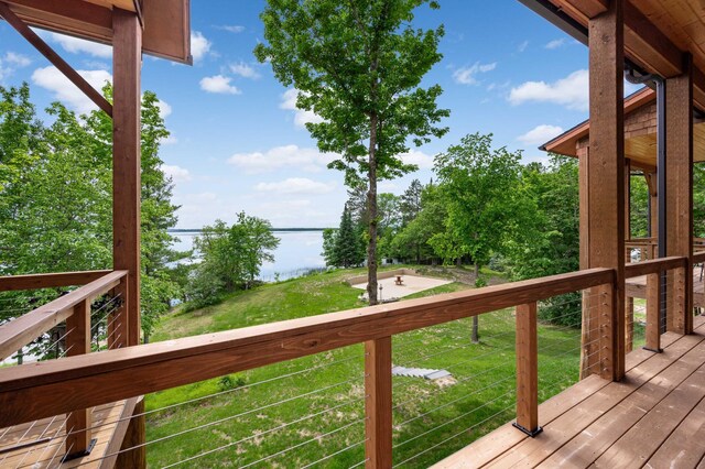 wooden terrace with a lawn and a water view