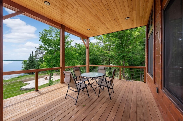 wooden deck featuring outdoor dining space and a water view