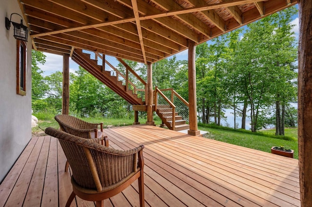 wooden terrace featuring stairs and a lawn