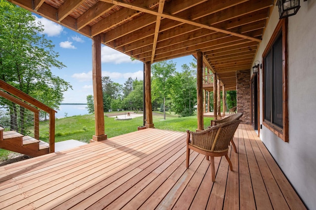 wooden deck with a lawn and a water view