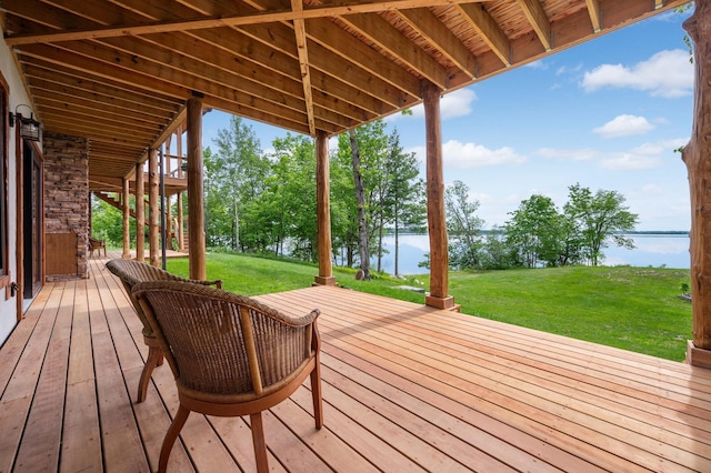 wooden deck featuring a water view and a lawn