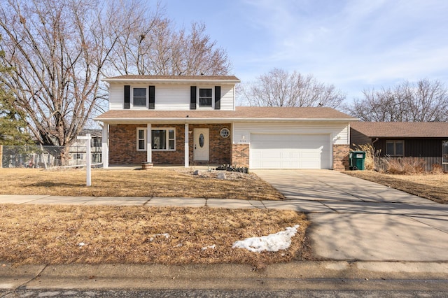 traditional-style home with an attached garage, fence, brick siding, and driveway