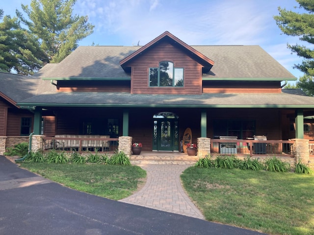 view of front of house featuring covered porch and a front yard