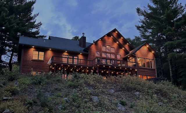 back of house featuring a chimney and a deck