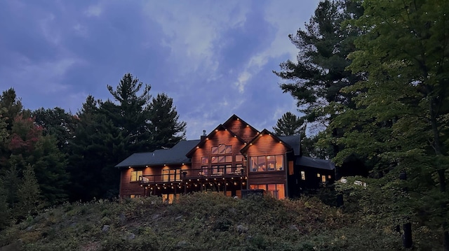 back of property featuring log veneer siding and a wooden deck