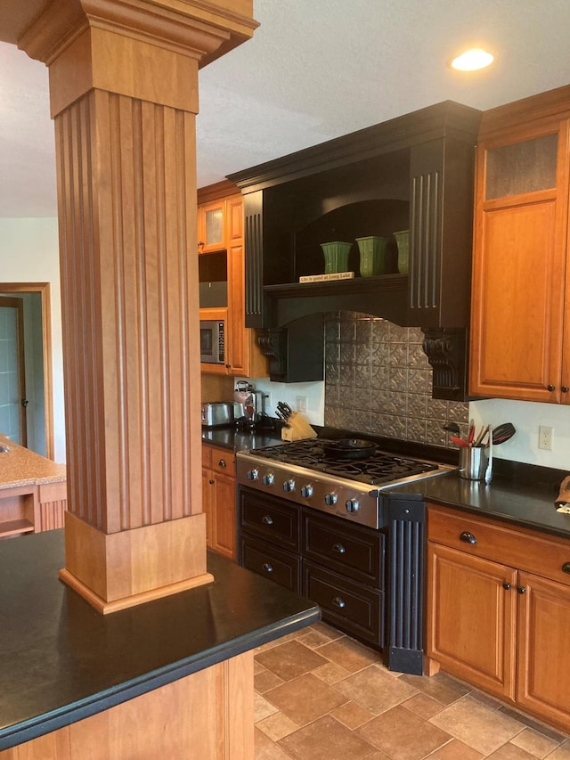 kitchen featuring stainless steel appliances, dark countertops, and decorative backsplash