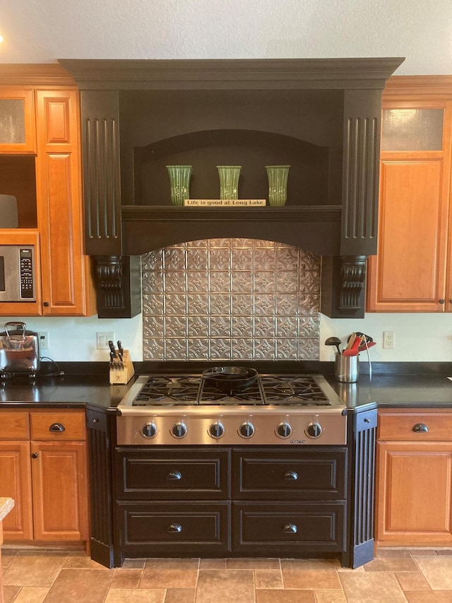 kitchen with a textured ceiling, stainless steel appliances, dark countertops, and open shelves