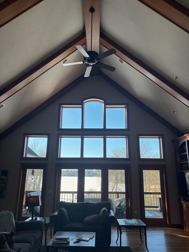 living area featuring high vaulted ceiling, dark wood-style flooring, and beam ceiling