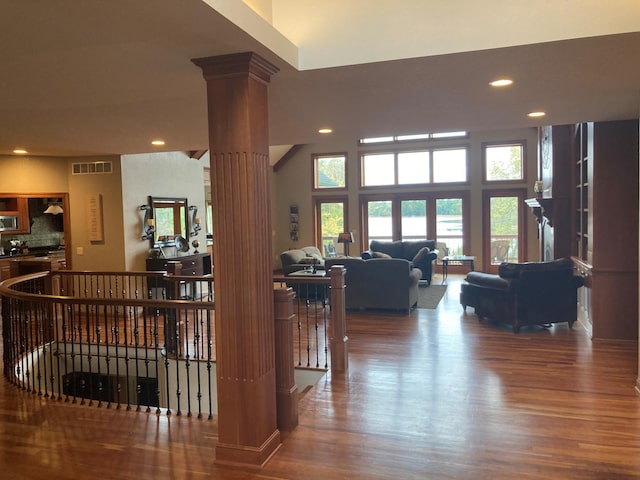 living room with decorative columns, visible vents, wood finished floors, and recessed lighting