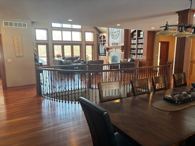 dining space featuring recessed lighting, a fireplace, wood finished floors, visible vents, and baseboards