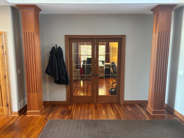 doorway to outside with french doors, ornate columns, and wood finished floors