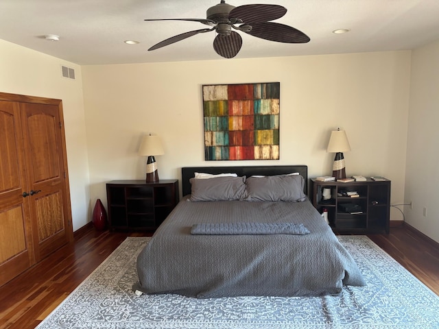 bedroom featuring ceiling fan, wood finished floors, visible vents, and baseboards