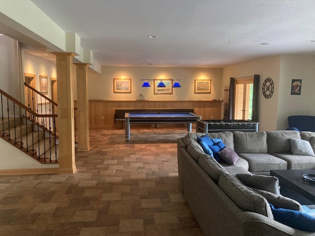 playroom with a wainscoted wall, wood walls, and ornate columns