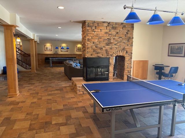 recreation room featuring a wainscoted wall, a fireplace, and recessed lighting