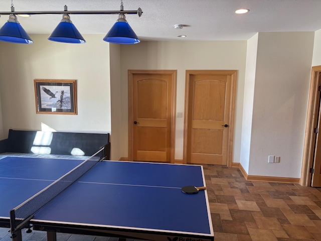 game room featuring recessed lighting, stone finish flooring, and baseboards