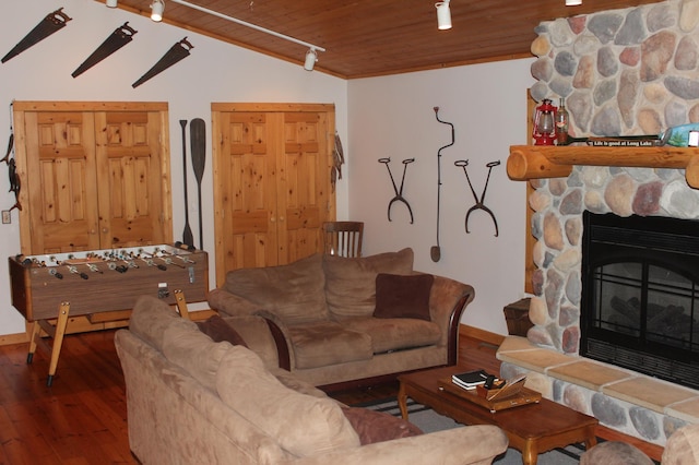 living room featuring lofted ceiling, wood ceiling, wood-type flooring, and a stone fireplace