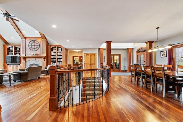 7251 County Rd B, Siren Twp, WI 54872 - interior space featuring ornate columns, light wood-style flooring, a fireplace, and a ceiling fan