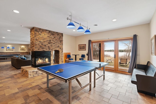 7251 County Rd B, Siren Twp, WI 54872 - playroom featuring recessed lighting, a stone fireplace, a water view, and visible vents