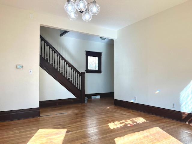 interior space with visible vents, stairway, baseboards, and wood finished floors