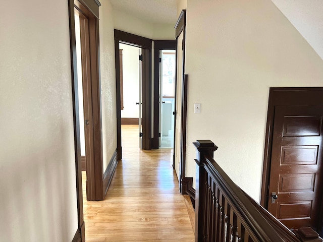 hall featuring light wood finished floors and baseboards