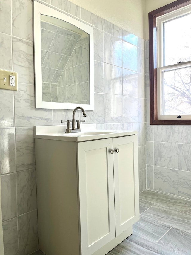 bathroom with vanity and tile walls