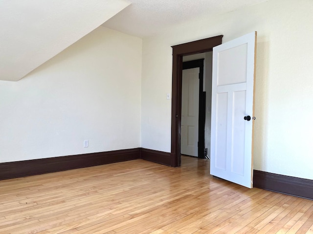 bonus room with light wood-style flooring and baseboards