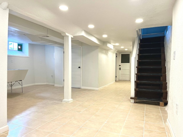 below grade area featuring light tile patterned floors, stairs, baseboards, and recessed lighting