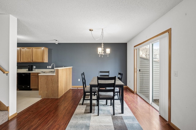 dining area with a textured ceiling, stairway, an inviting chandelier, baseboards, and dark wood-style flooring