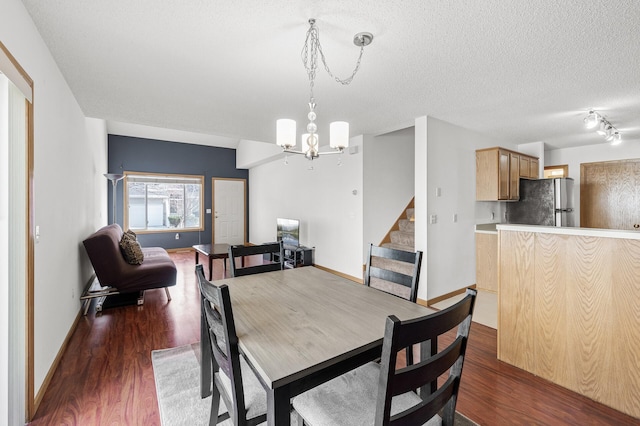 dining room with baseboards, dark wood finished floors, stairway, a notable chandelier, and a textured ceiling