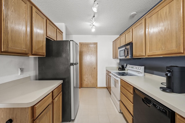 kitchen with brown cabinets, track lighting, a textured ceiling, appliances with stainless steel finishes, and light countertops