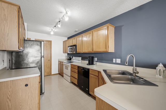 kitchen with track lighting, a sink, a textured ceiling, stainless steel appliances, and light countertops