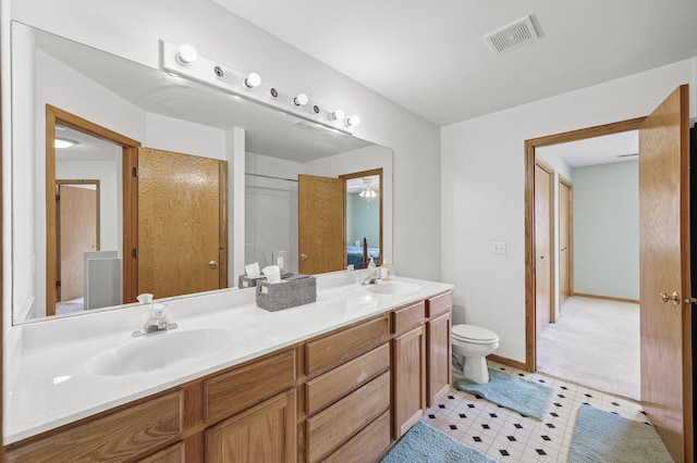 bathroom featuring a sink, visible vents, toilet, and double vanity