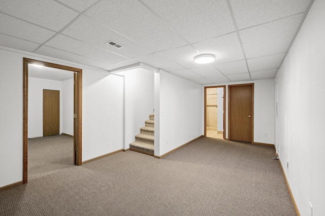 finished basement with stairs, baseboards, visible vents, and carpet floors