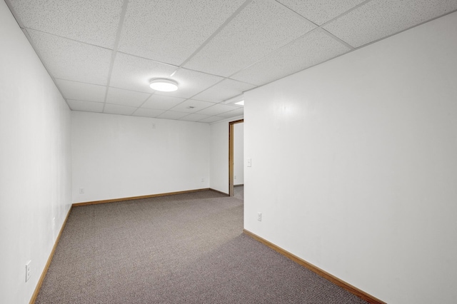 unfurnished room with carpet, baseboards, and a paneled ceiling