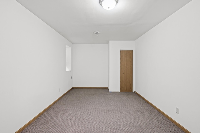 spare room with carpet, visible vents, and baseboards