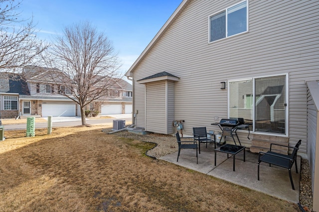 rear view of property with central air condition unit, a patio, and a lawn