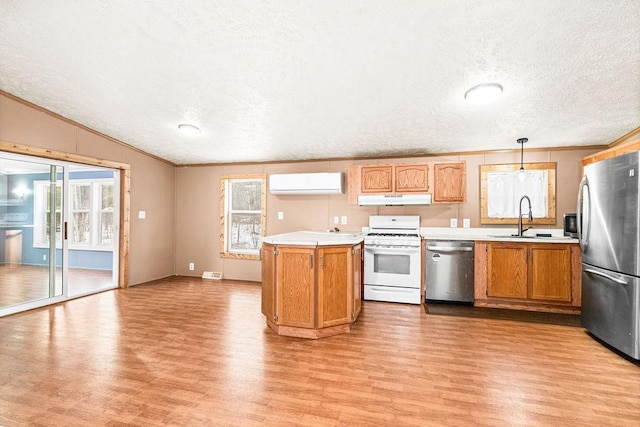 kitchen featuring a wall unit AC, stainless steel appliances, light countertops, a sink, and under cabinet range hood