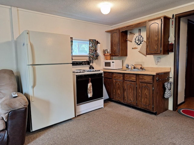 kitchen with a textured ceiling, white appliances, a sink, light countertops, and dark brown cabinets