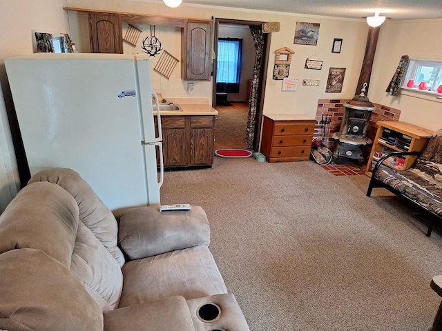 living area with a wood stove, light carpet, plenty of natural light, and a textured ceiling