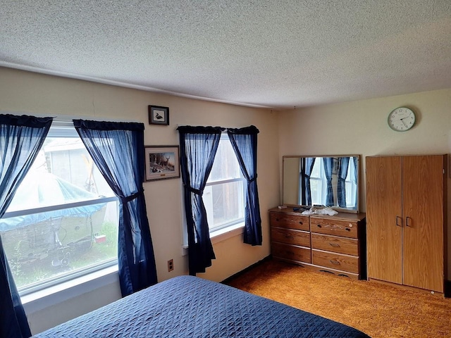 bedroom with light carpet and a textured ceiling