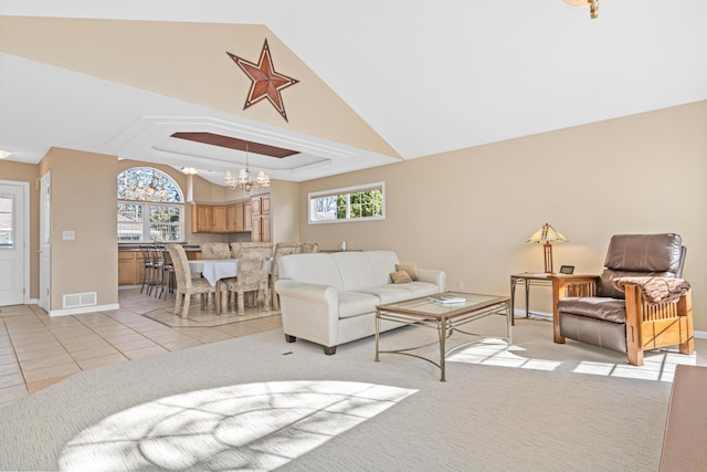 living room with light tile patterned floors, visible vents, an inviting chandelier, a tray ceiling, and light carpet