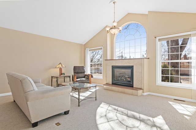 carpeted living room featuring an inviting chandelier, a fireplace, visible vents, and baseboards