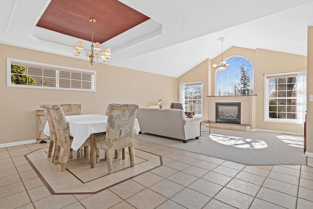 dining area with a raised ceiling, light tile patterned flooring, and a chandelier