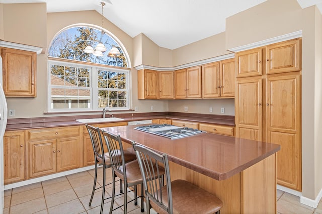 kitchen featuring lofted ceiling, light tile patterned flooring, a sink, a kitchen bar, and a center island