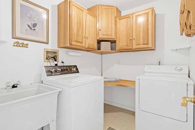 laundry area with cabinet space, independent washer and dryer, and a sink