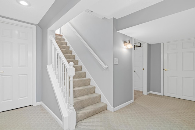 stairway with a notable chandelier, carpet flooring, and baseboards