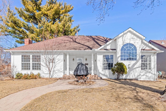 view of front of home featuring a chimney and a shingled roof